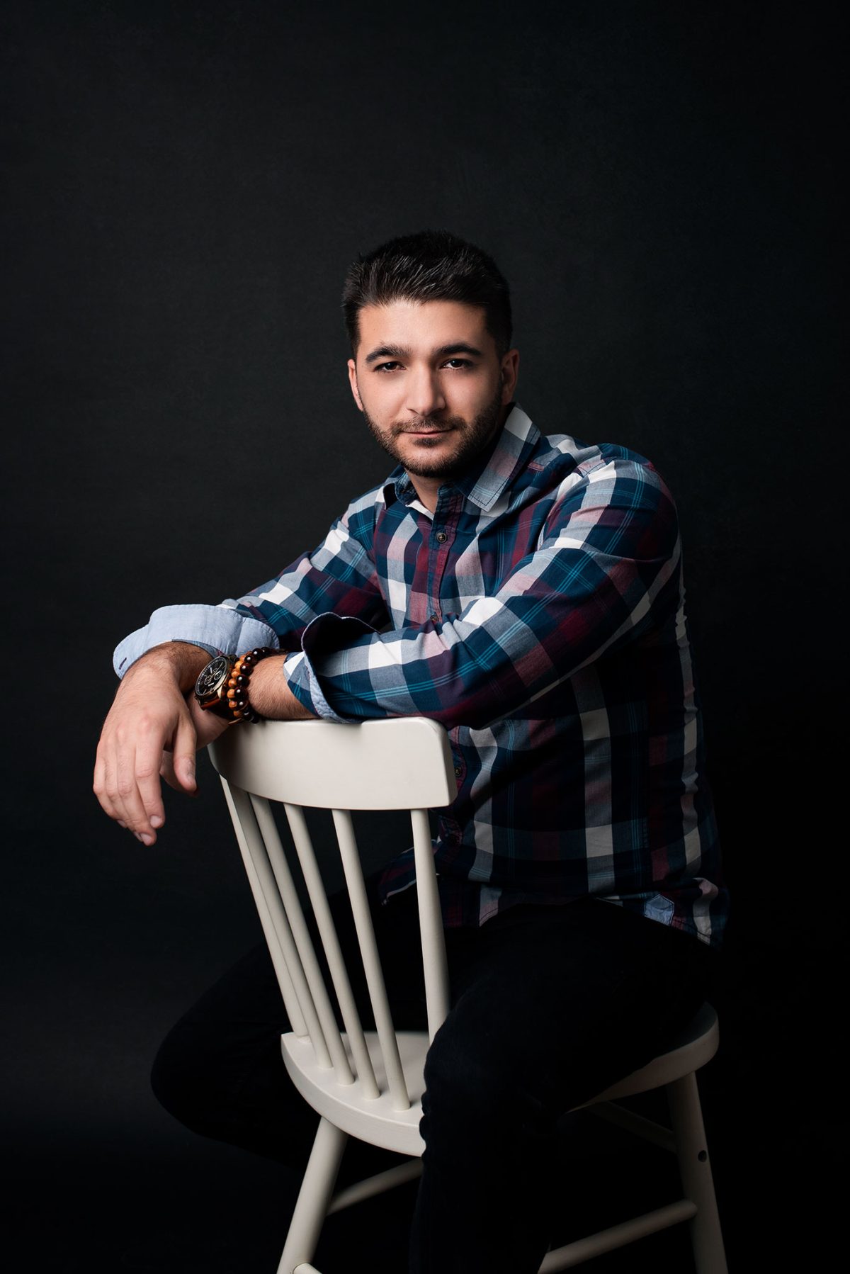 Portrait expressif d’un entrepreneur photographié en studio dans le Vexin – homme assis sur fond noir