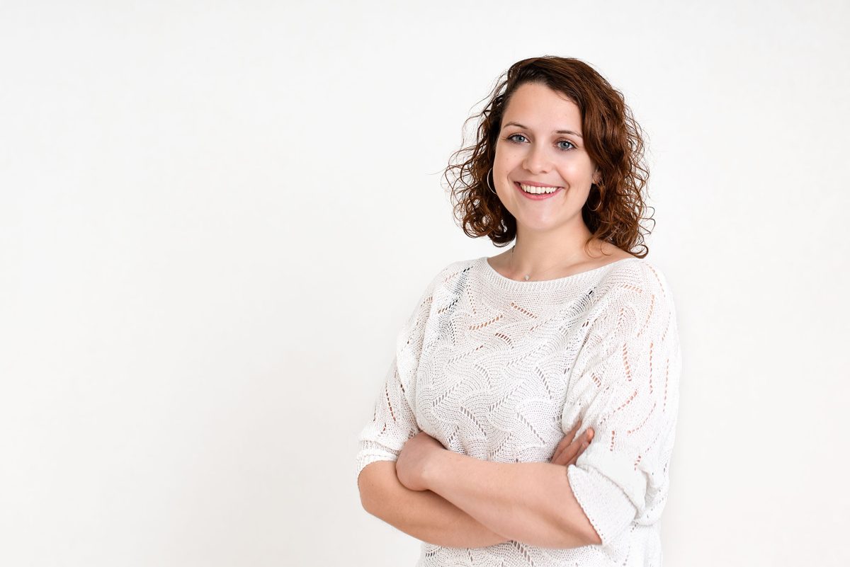 photo pro en studio dans le vVxin - Femme souriante posant sur fond blanc
