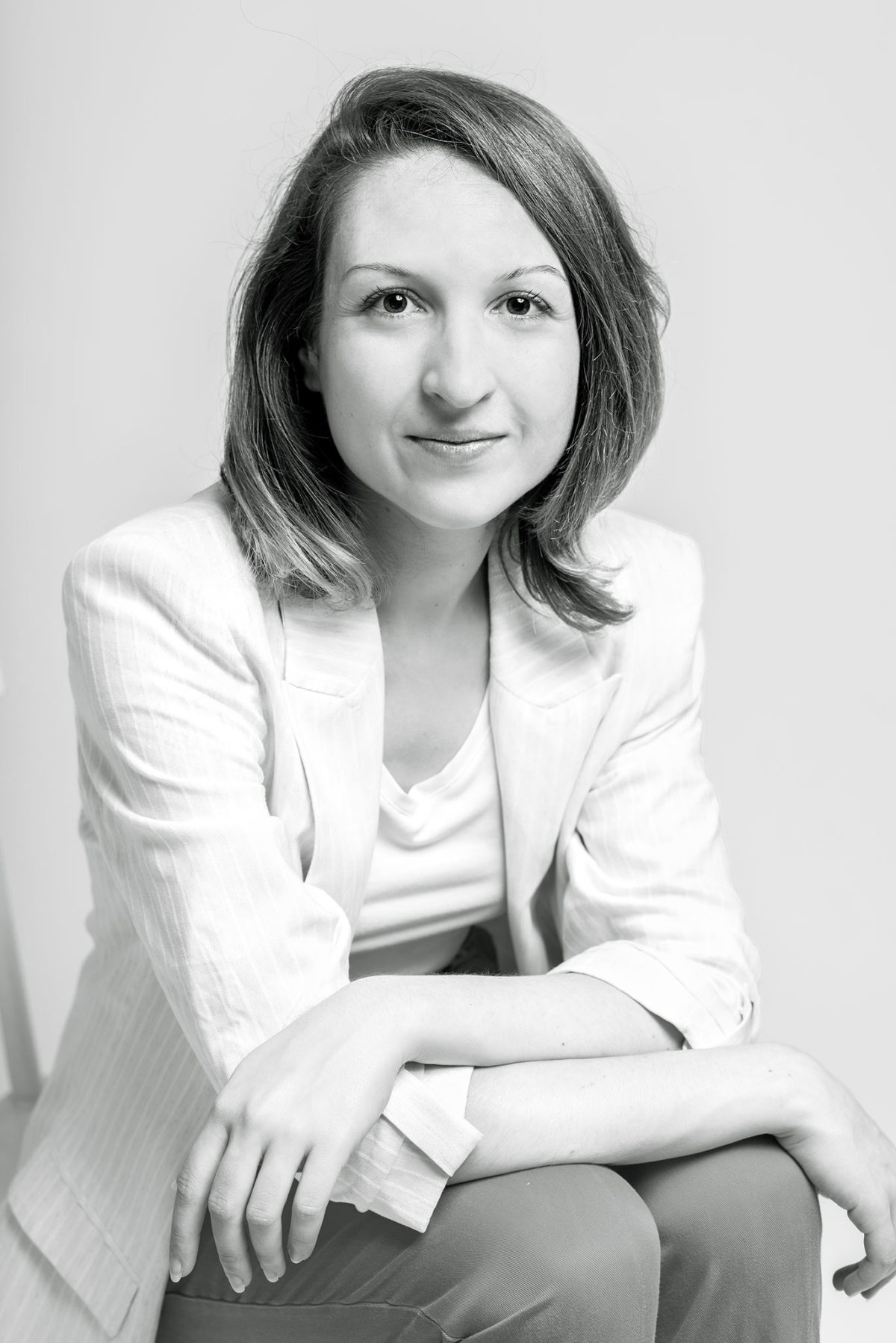 Photo professionnelle en studio réalisée par Laure Halabura à Cergy dans le Val d'Oise - Femme assise fond blanc